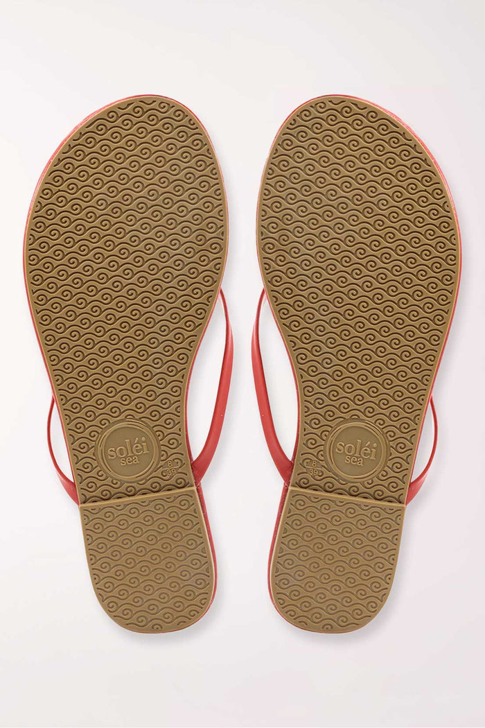 Pair of orange flip-flops on a white background