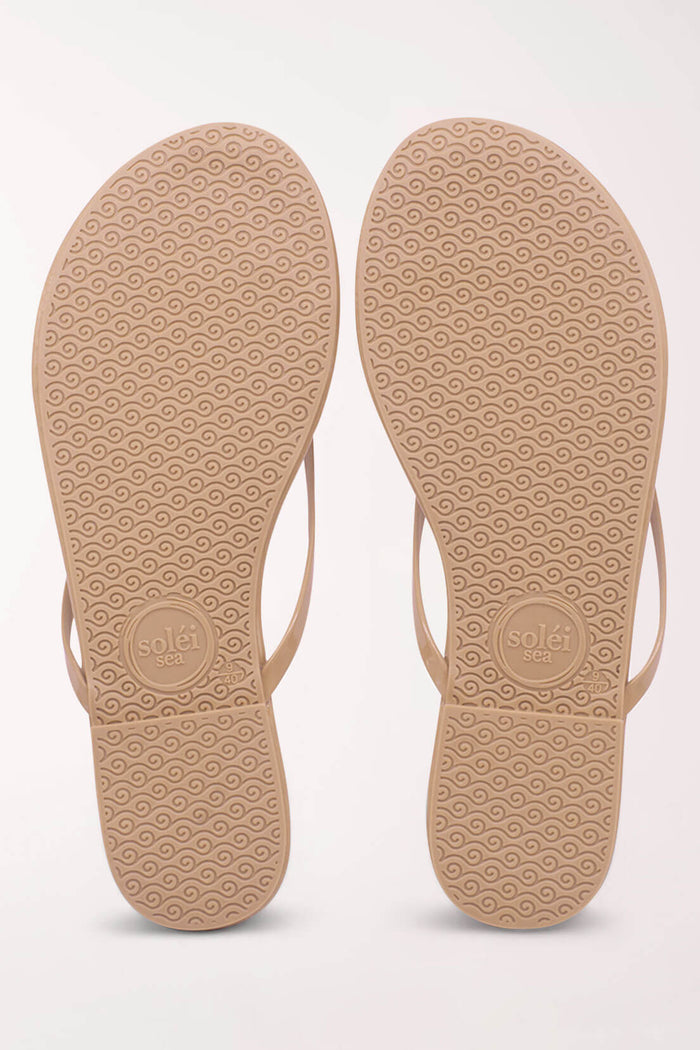 Beige flip-flop sandals with textured soles on a white background