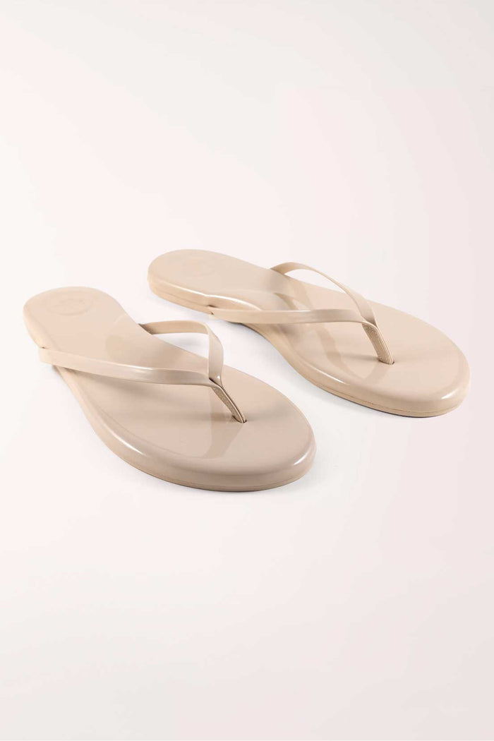 Pair of beige flip-flops on a white background