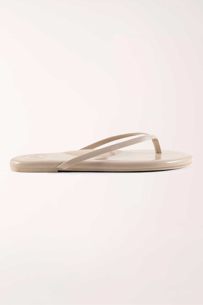 Pair of beige flip-flops on a white background
