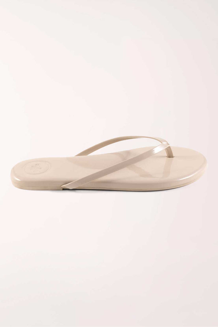 Pair of beige flip-flops on a white background