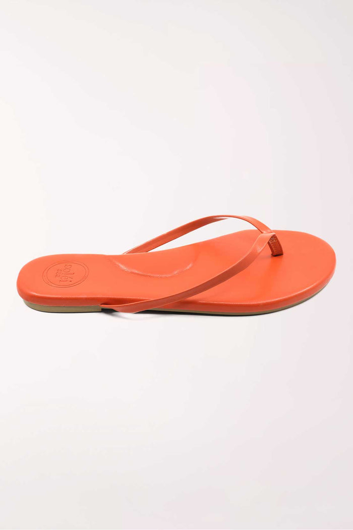 Pair of orange flip-flops on a white background