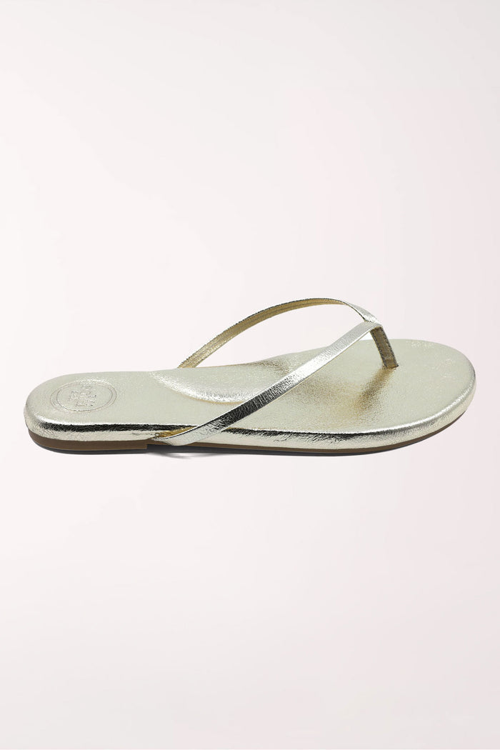 Pair of gold metallic sandals on a white background