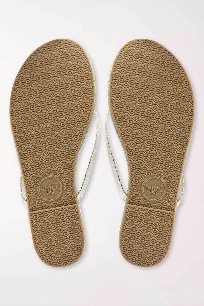 Pair of gold metallic sandals on a white background