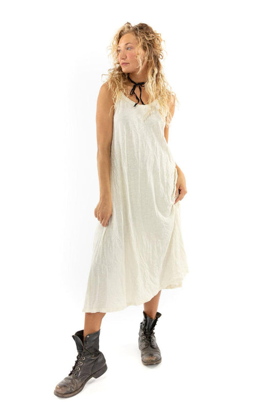 Woman in Magnolia Pearl artisan white vintage-style dress, whimsical design, rustic boots
