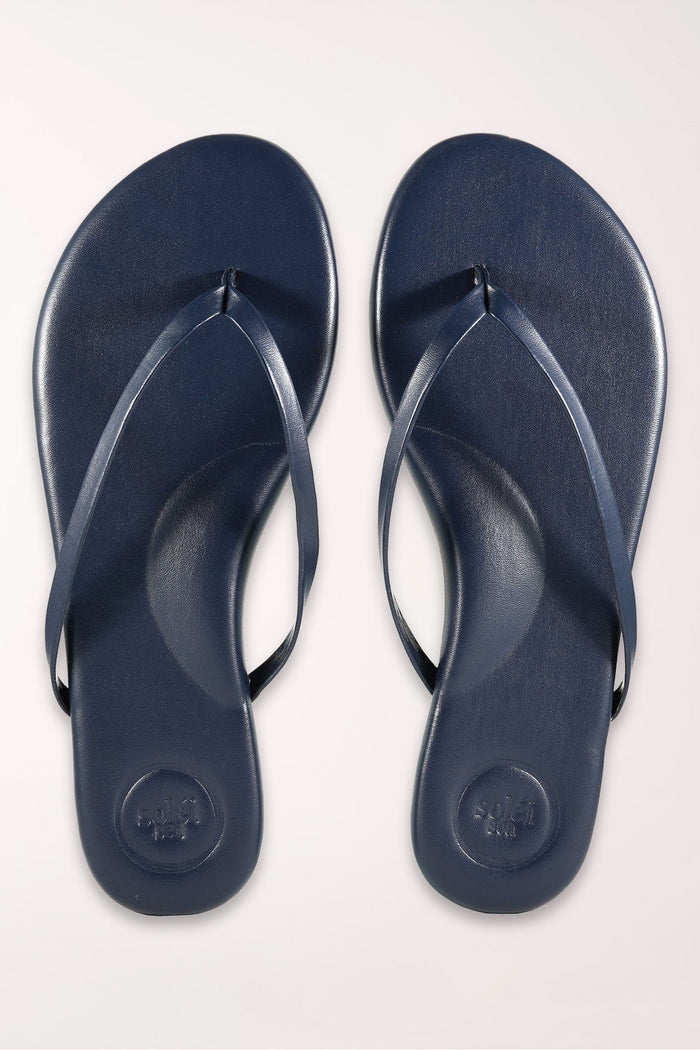 Pair of navy blue flip-flops on a white background