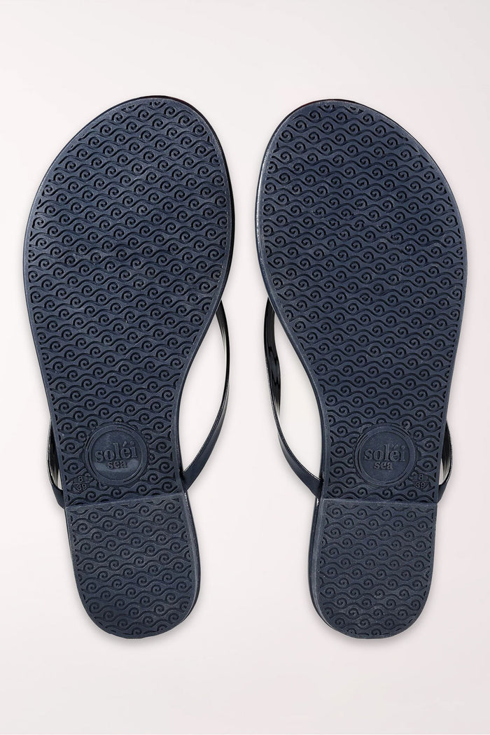 Pair of navy blue flip-flops on a white background