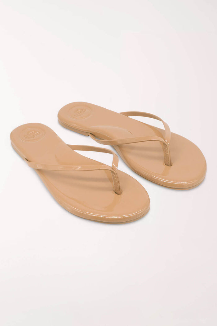 Pair of beige flip-flops on a white background