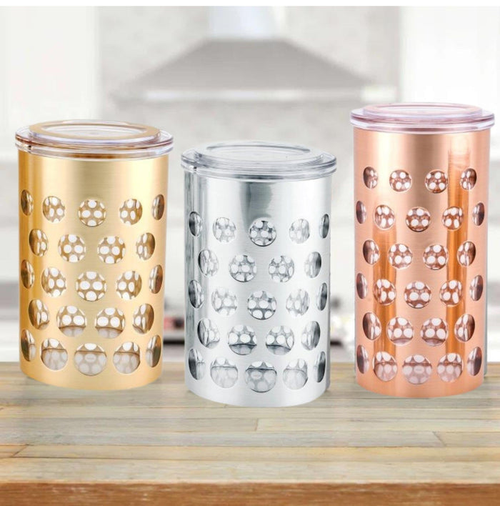Three airtight storage jars in gold, silver, and rose with clear lids and polka dots.