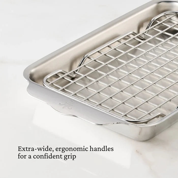 Stainless steel roasting pan with wire rack on a white background