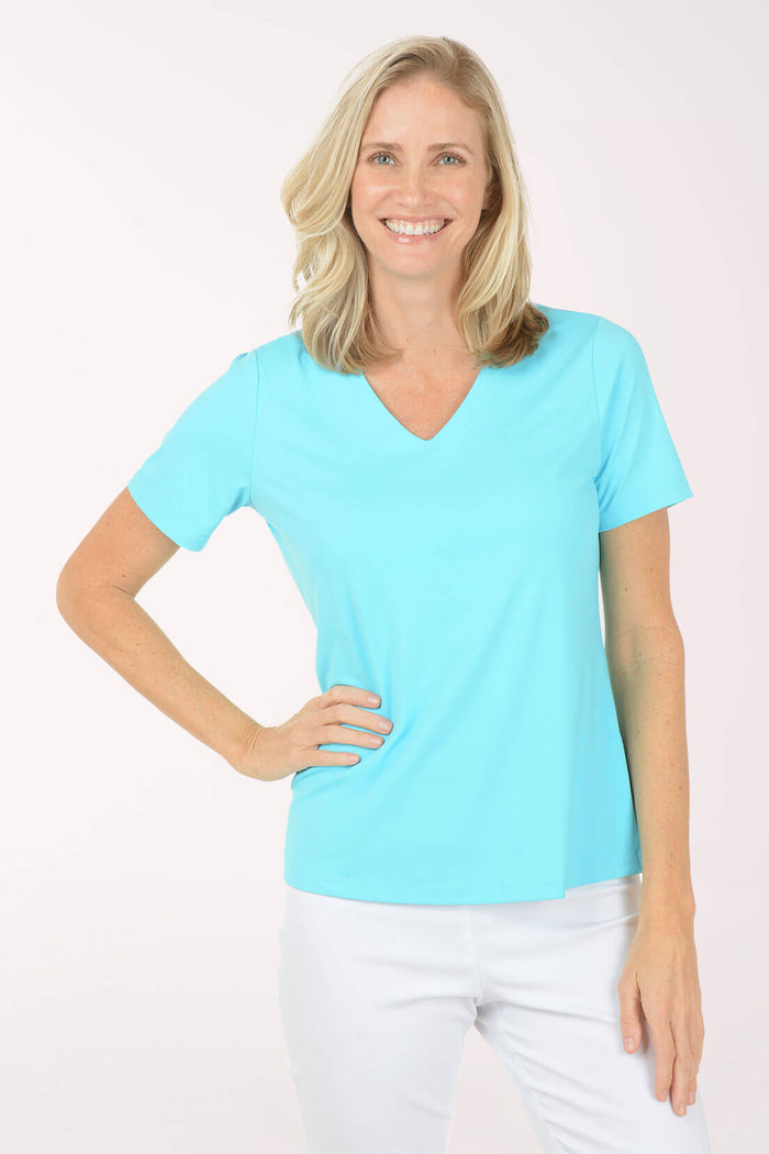 Woman wearing a light blue t-shirt and white pants on a white background