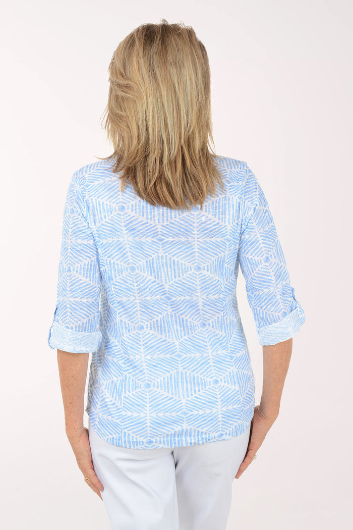 Woman wearing a light blue patterned shirt on a white background