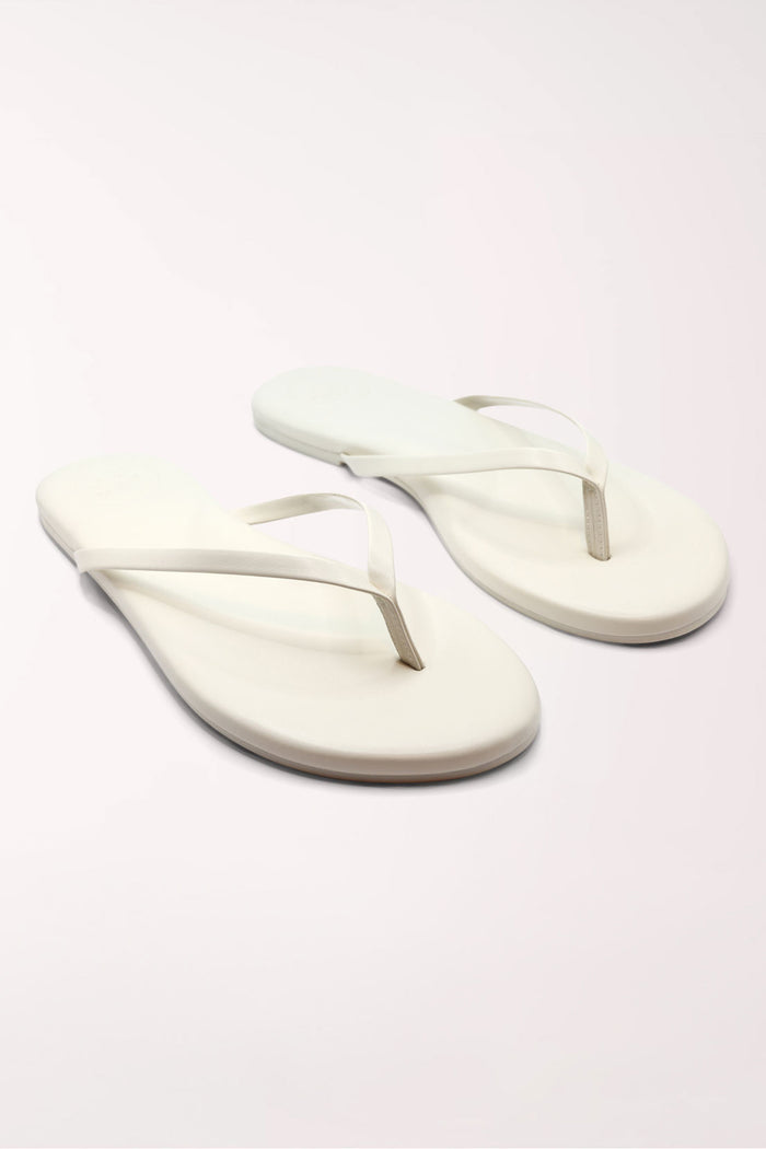 Pair of white flip-flops on a light gray background