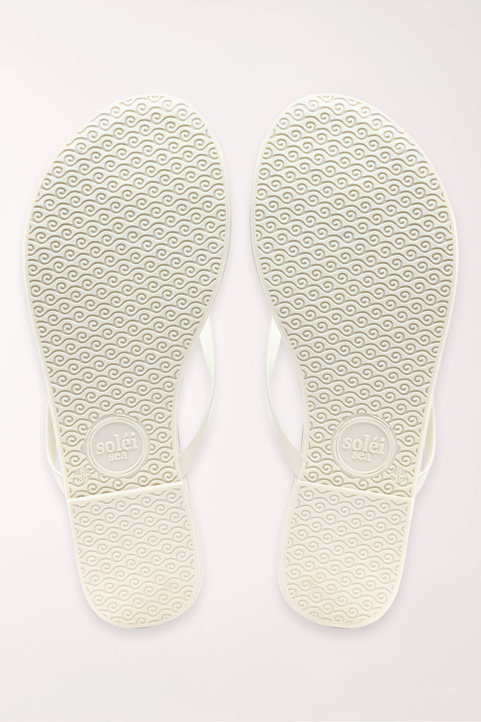 Pair of white flip-flops on a light gray background